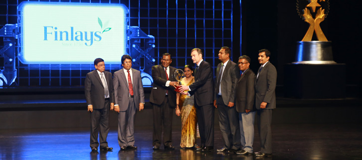 Finlays Colombo’s Managing Director Hunter Crawford (fourth from the right) receives the trophy from Mr W. D. J. Senevirathne, Minister of Labour & Trade Union Relations.