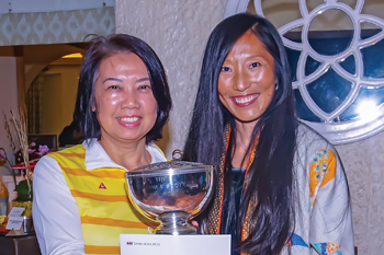 Vera Yuen (left), spouse of Cathay Pacific Catering Services staff, receives the Rose Bowl trophy from Mrs. Healy.