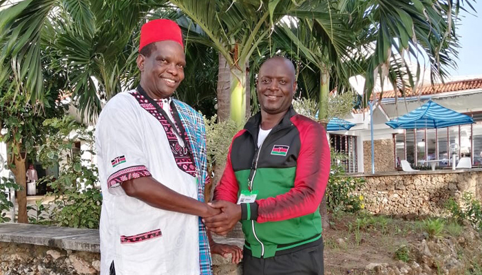 Sammy Kirui (left) is congratulated by one of the state officials.