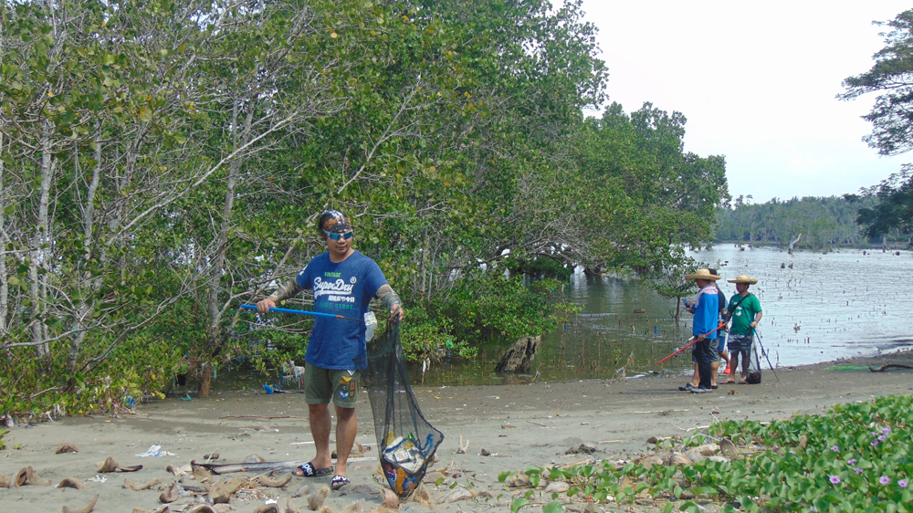 Volunteers removing plastic debris within a large mangrove protected area.
