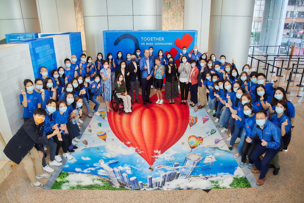 Chief Executive of Swire Properties Tim Blackburn and Hong Kong’s Olympic cycling medalist Sarah Lee (centre) officiated at the launch of the ‘Community Ambassadors Together for 20 Years’ roving exhibition.