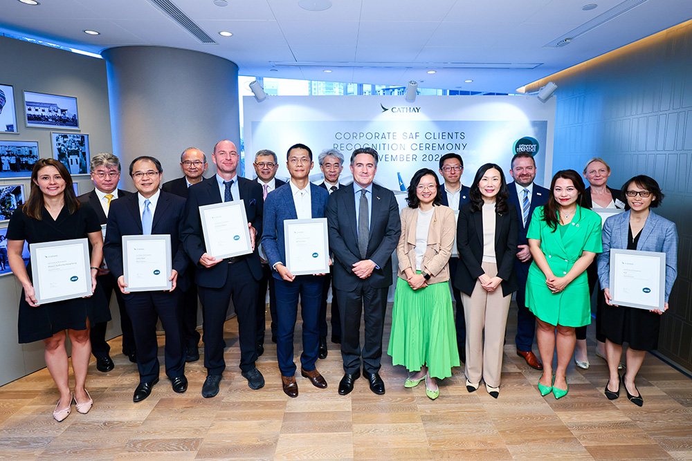 Corporate SAF Programme partners (holding certificates) celebrate their shared commitment with (front row, left to right from centre) Cathay Director Cargo Tom Owen; Cathay General Manager Group Sustainability, Grace Cheung, and Cathay Director Customer Travel, Erica Peng.