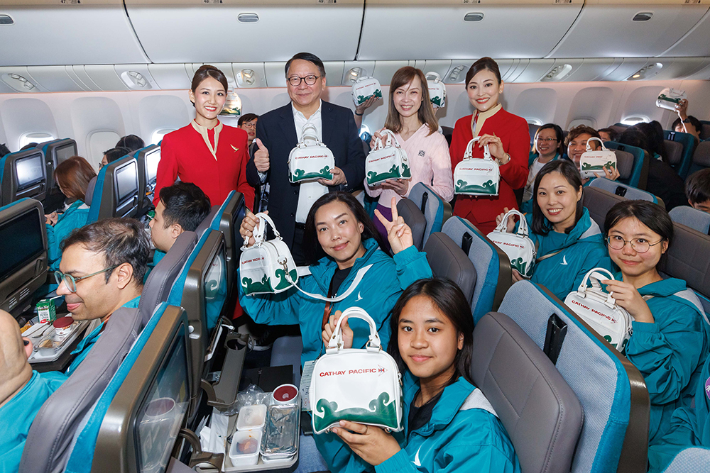 Chief Secretary for Administration of the HKSAR Government Mr Eric Chan Kwok-ki and Cathay Chief Customer and Commercial Officer Lavinia Lau distribute souvenirs to the students.